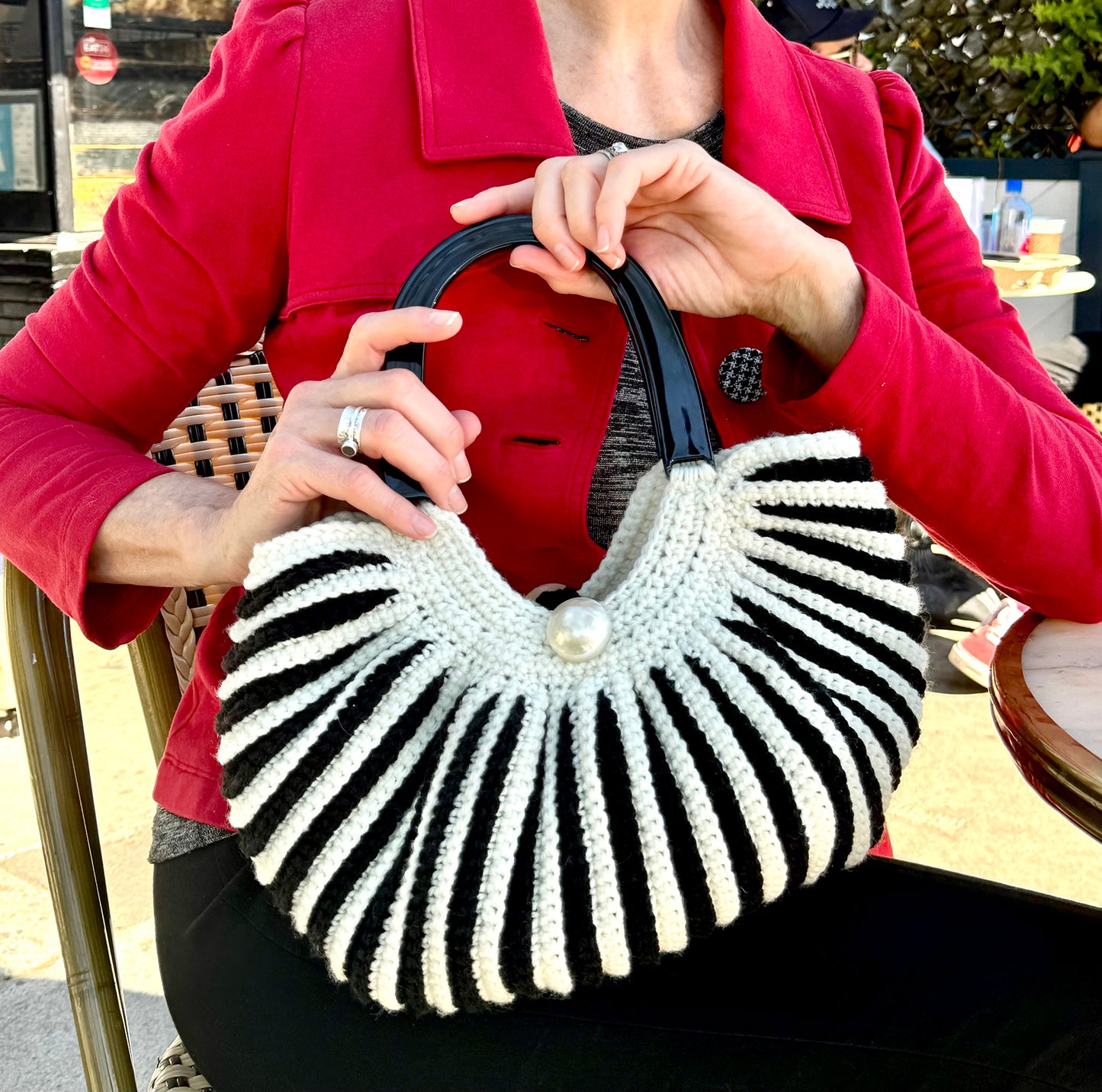 Black & white stripe, vintage crocheted bag is a homage to the 60's chic style of Brigette Bardot. 6" black Lucite twin handles and large pearl button closure on each side. Hand crocheted with upcycled acrylic yarn by Oda G. exclusively for MarVia Square. Dimensions: Height:15" Length:13" Width: 6" Hand wash cold Made in California