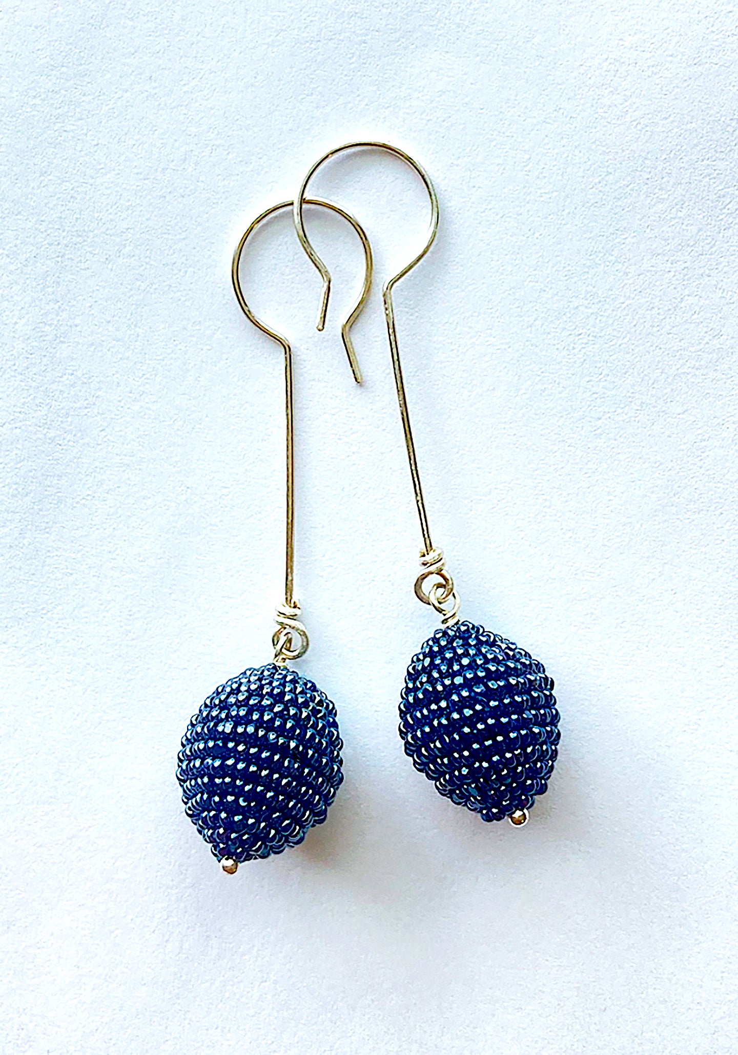 Artist, Iva Hladis, has created an exquisite collection of elegant beaded earrings that will stand out in any event. Gunmetal wool ball embellished with glass micro beads, sterling silver earwire & headpin. Length: 2.5" Ball: 3/4"