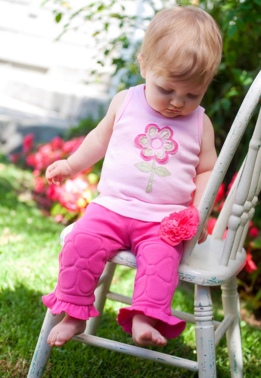 Baby Girl sitting on a chair outdoors with a garden background. Girls love flowers, and love the soft texture of the hand crafted flower appliques on a comfy, cotton rib knit, tank top. Classic binding around neckline and shoulders, with lettuce trim hem. *These tops sell quickly! If the size/color you need is sold out, send us a request email with the size & color, and your top will be completed in 7 - 10 days. 100% Cotton Wash Cold, turn inside out, Line Dry Consciously made in California