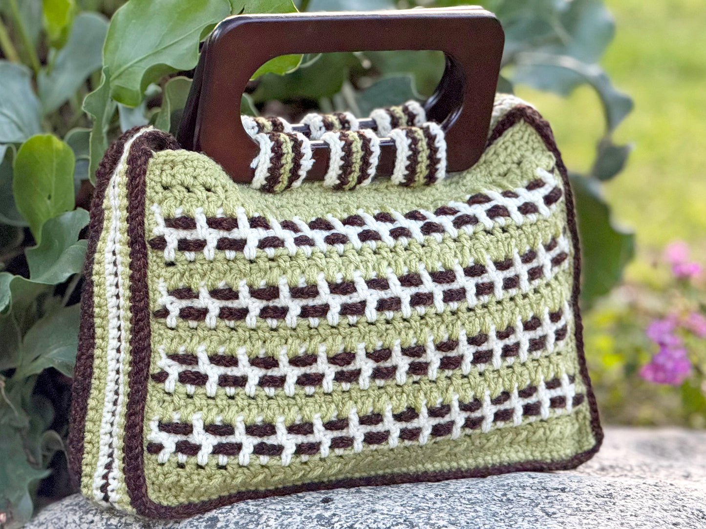 Bali's bamboo forests reflect in this crossbody style crochet bag by Oda G. Eco-conscious with up-cycled, cotton blend yarn in sage, cream and espresso, and fully lined with espresso satin fabric. Dark wood handles, and 20" strap that can be conveniently tucked inside the bag. Can be special ordered in a larger size and or color preference, if yarn color is available. Please email us your request and when the design is approved and deposit is made, (depending on the size requested), please allow up to 2 wee