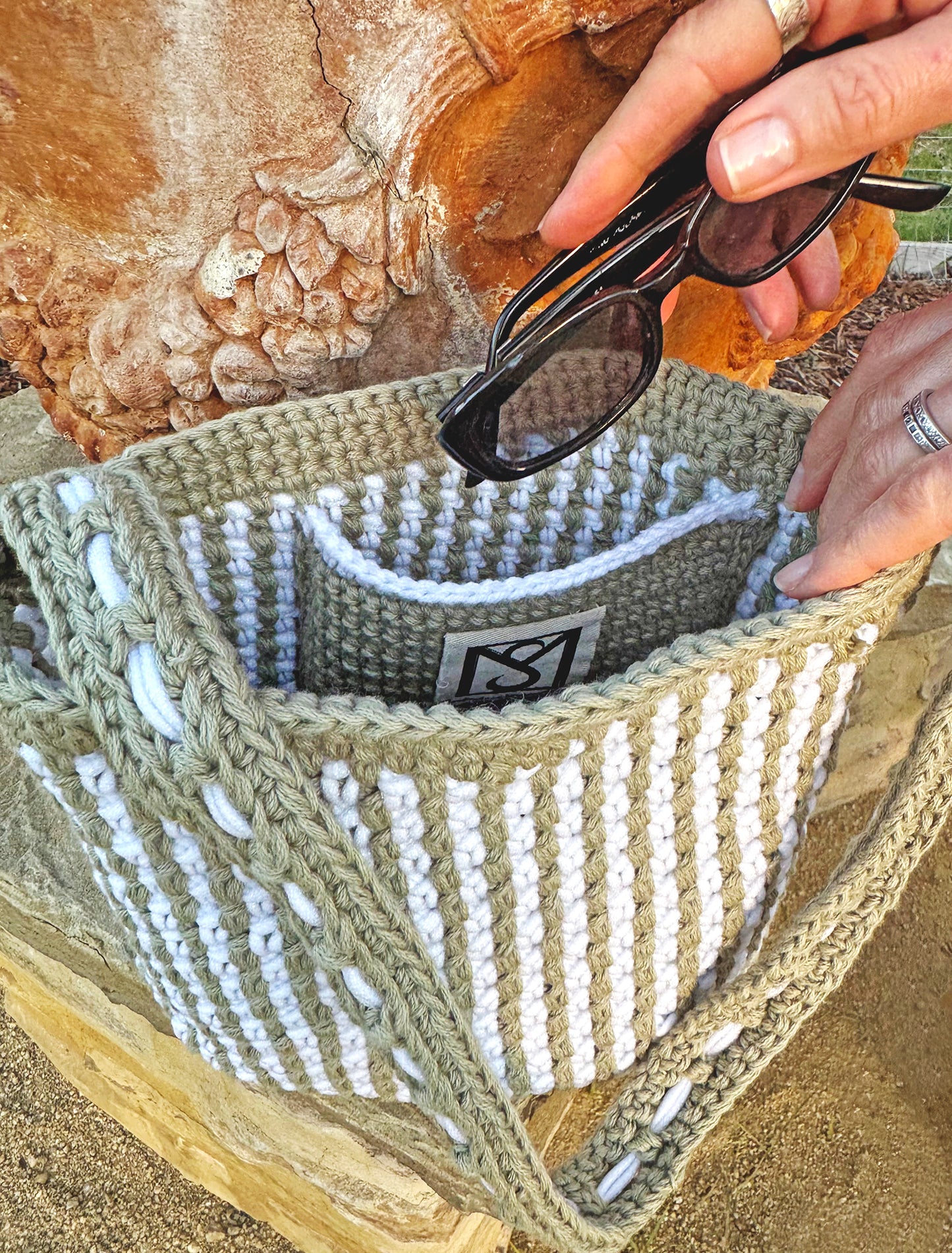 Summer in the south of France best describes the Mediterranean style, Canet crochet bucket bag, created by artisan extraordinaire, Oda G. Light weight, yet strong and durable with a cotton blend yarn in a two tone design. Two interior pockets are perfect to hold your phone and sunglasses separately, making this timeless chic bag a dream vacation companion. Dimensions: 9" high, 11" long, 7" wide, 20" high (with strap) Spot treat with mild soap or Dry Clean Consciously made in California