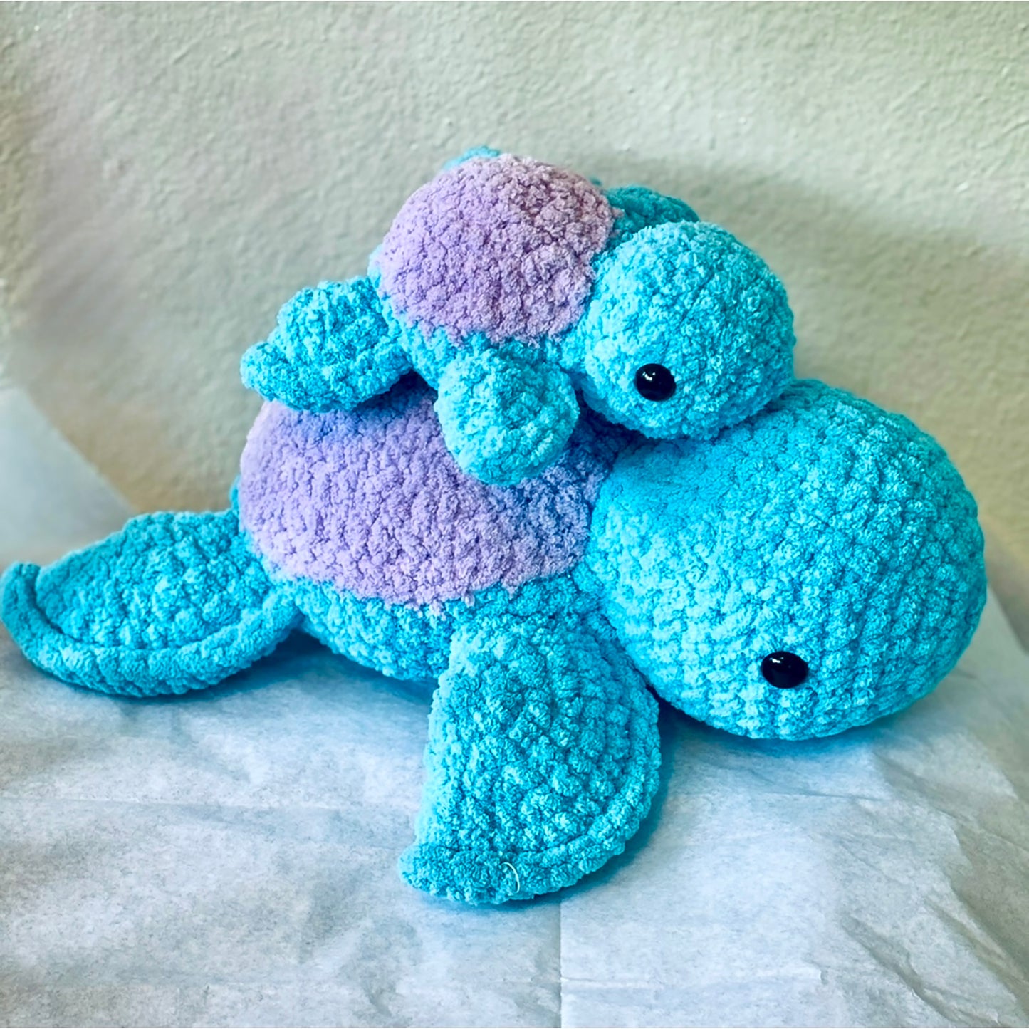 Cutest crochet plushie Sea Turtle collectibles are hand crocheted by Anya, MarVia Square's youngest artisan. Made with the softest, plush acrylic yarn and black mushroom bead (plastic) buttons for the eyes. Colors shown are turquoise & lavender. Other colors may be available upon request. Please allow 7 to 10 days to complete. Dimensions: Baby: 6.5" Long, 7.5"/Mama:12" Long, 13.5" Wide Spot treat with mild soap, or dry clean. Consciously made in California. For ages 3+