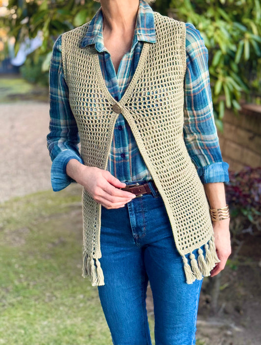 Hand crocheted with up-cycled, cotton blend yarn, this long style crochet vest in a beautiful sage color, fits small and medium sizes. Fun fringe trim on bottom hem and vintage silver button, snap closure at the bust. Size: Small / Medium Length: (from top of shoulder) Front - 32", Back - 33" Hand wash cold, Line dry or Dry clean Consciously made in the USA