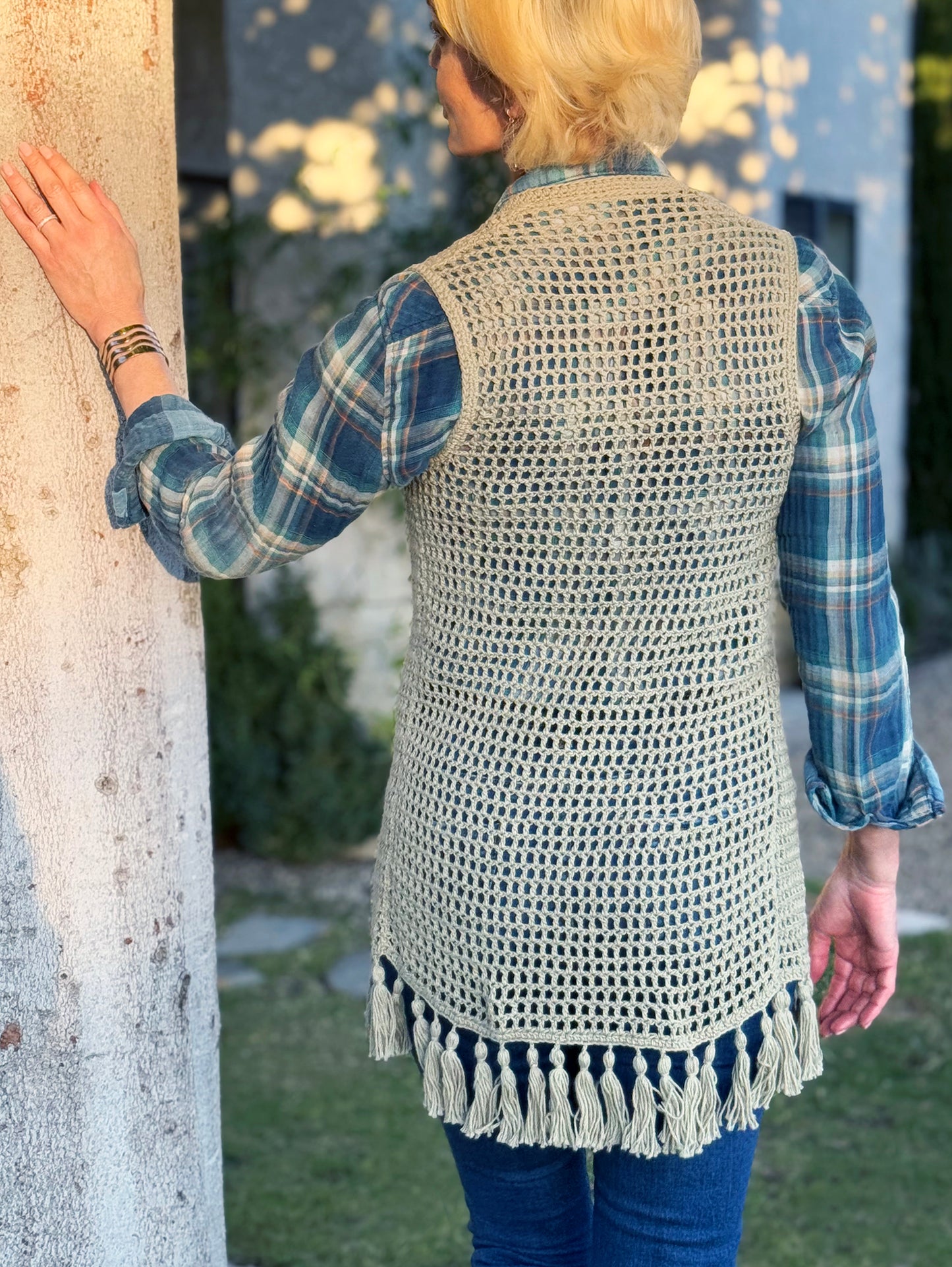 Hand crocheted with up-cycled, cotton blend yarn, this long style crochet vest in a beautiful sage color, fits small and medium sizes. Fun fringe trim on bottom hem and vintage silver button, snap closure at the bust. Size: Small / Medium Length: (from top of shoulder) Front - 32", Back - 33" Hand wash cold, Line dry or Dry clean Consciously made in the USA