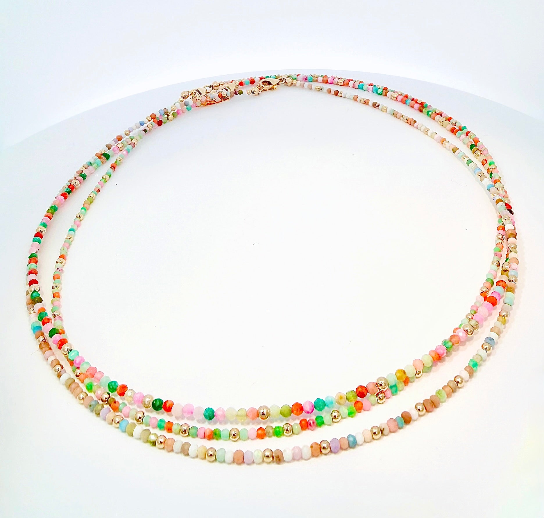 Elevate your summer essentials with gorgeous, multicolored, opal beaded necklaces. Handcrafted by Susan Sayble from her curated collection of Sayble Creations, each necklace is made with 14K gold filled beads, lobster clasp, and extender chain. Dimensions: 2.5mm beaded necklace: 15" length, 1.5" extender chain -OR- 2.0mm beaded necklace: 15" length, 1.5" extender chain Clean with polishing pad or soft cloth Consciously made in California
