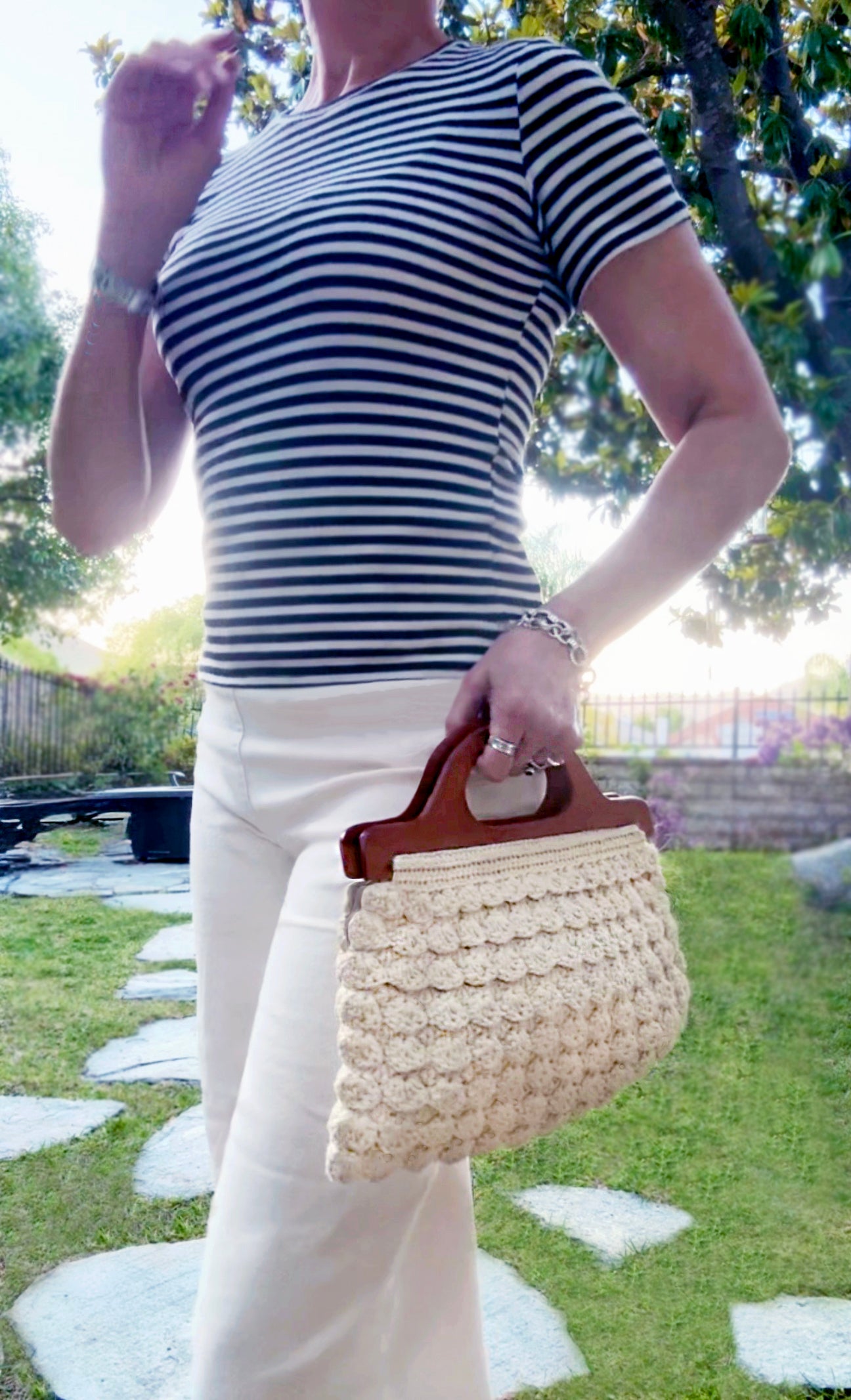The bohemian chic style in the Marais, Paris in the 70's, reflects in this scalloped, hand crocheted bag by Oda G., exclusively for MarVia Square. Fully lined with a small crocheted change purse inside, eco-conscious with up-cycled, cotton yarn, and wood handles that can be folded over to create a clutch style. Dimensions: 16"wide x 8"high / Handles: 12.5"wide x 3.5" high Color: Cream Consciously made in California