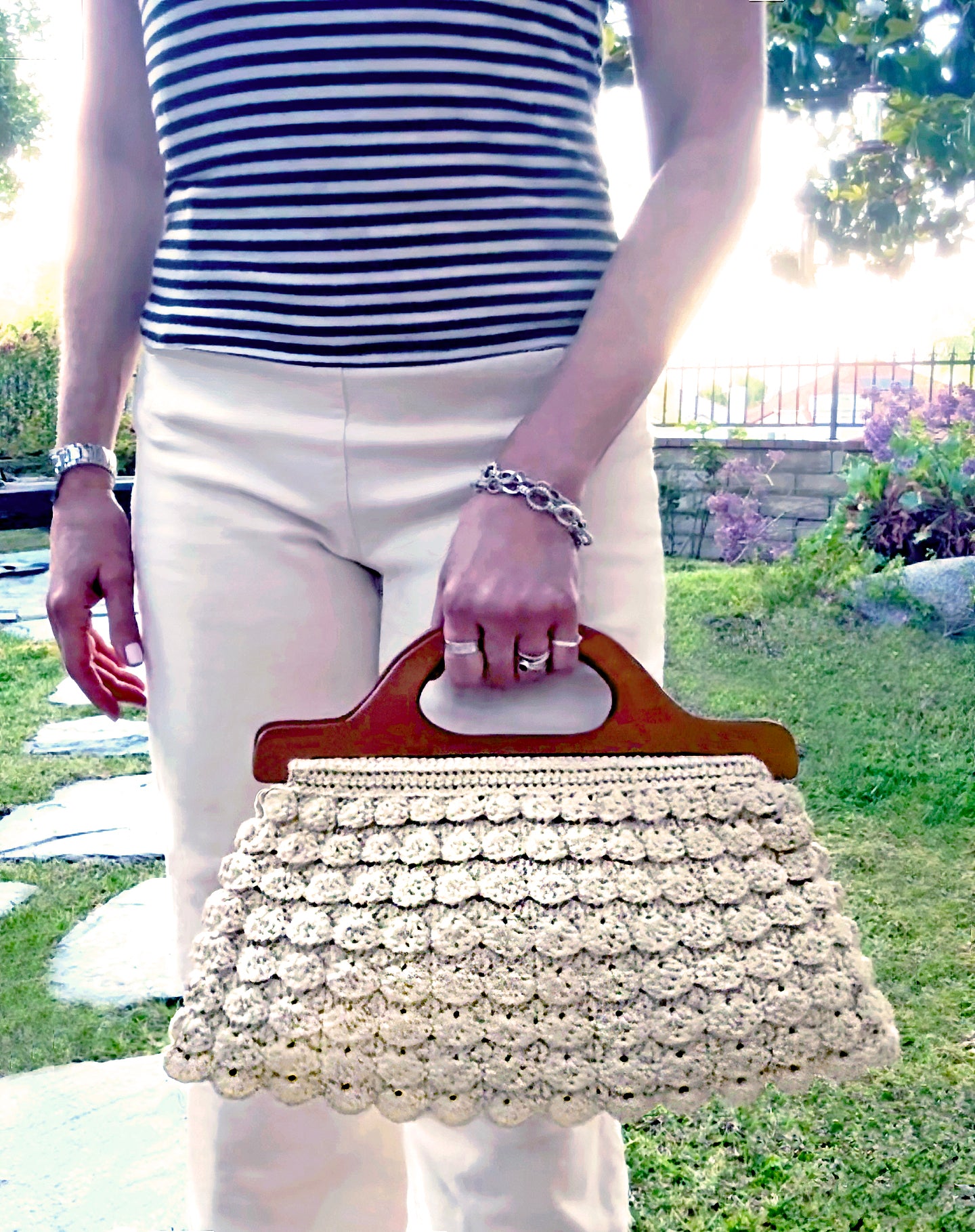 The bohemian chic style in the Marais, Paris in the 70's, reflects in this scalloped, hand crocheted bag by Oda G., exclusively for MarVia Square. Fully lined with a small crocheted change purse inside, eco-conscious with up-cycled, cotton yarn, and wood handles that can be folded over to create a clutch style. Dimensions: 16"wide x 8"high / Handles: 12.5"wide x 3.5" high Color: Cream Consciously made in California